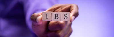 person holding wooden cube IBS sign 